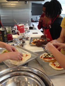 The whole group (even the staff) decorate a pizza for the last-day feast. 