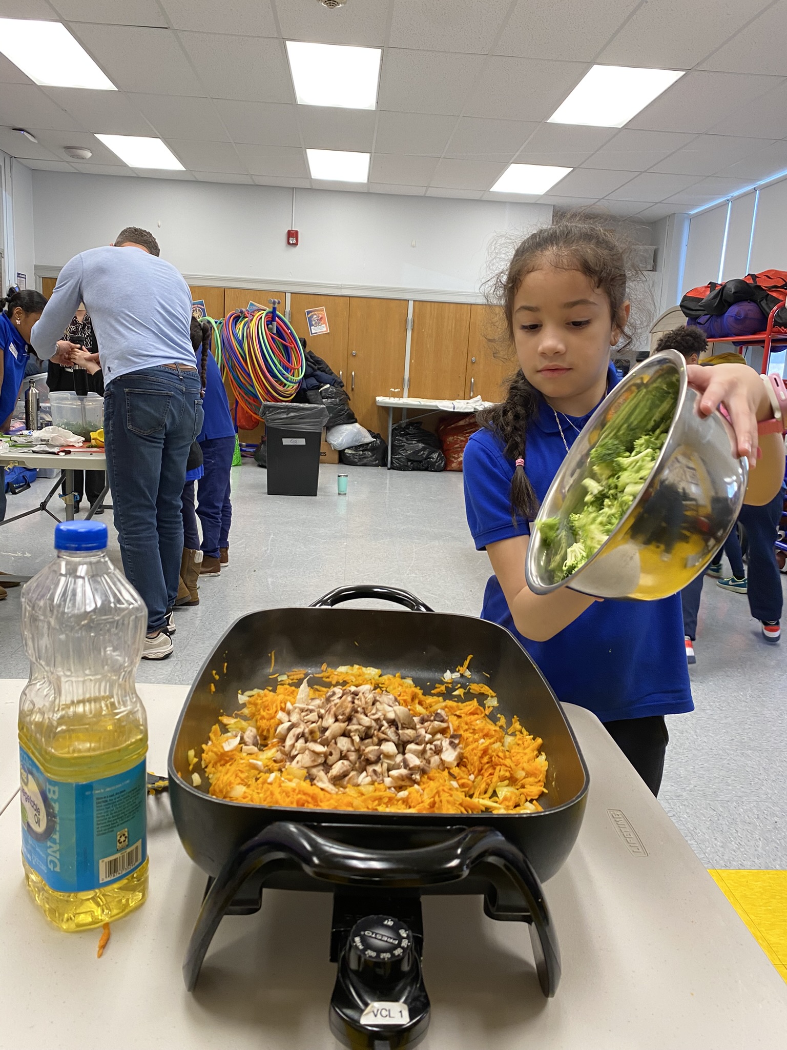 Carolina's Confidence: Carolina adding veggies to a skillet.